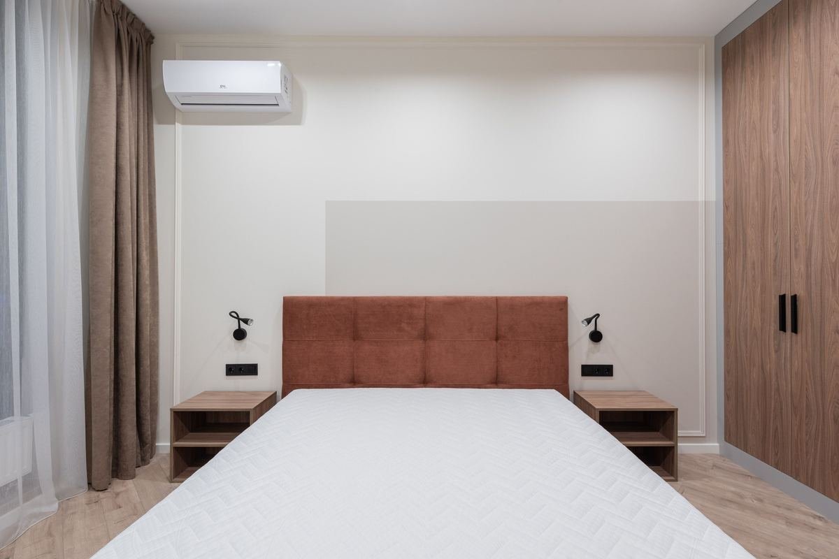 Ar-condicionado split instalado na parede de um quarto, ilustrando o consumo de energia do aparelho